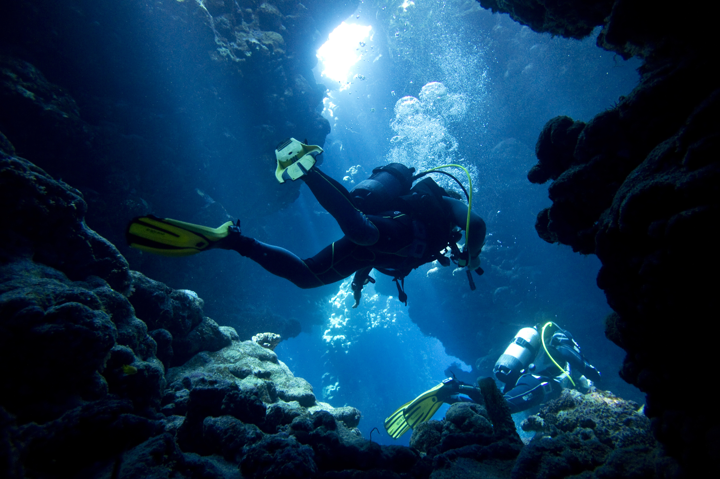 Scuba Diving: A couple of divers explore an underwater cave, Extreme water sport. 3010x2000 HD Background.