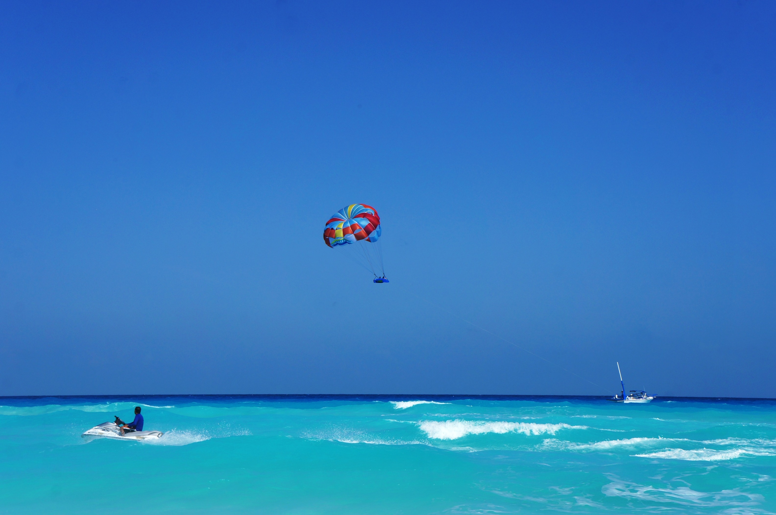 Parasailing: A person towed behind a boat, A specially designed canopy wing, Watercraft, Mexico. 3170x2110 HD Background.