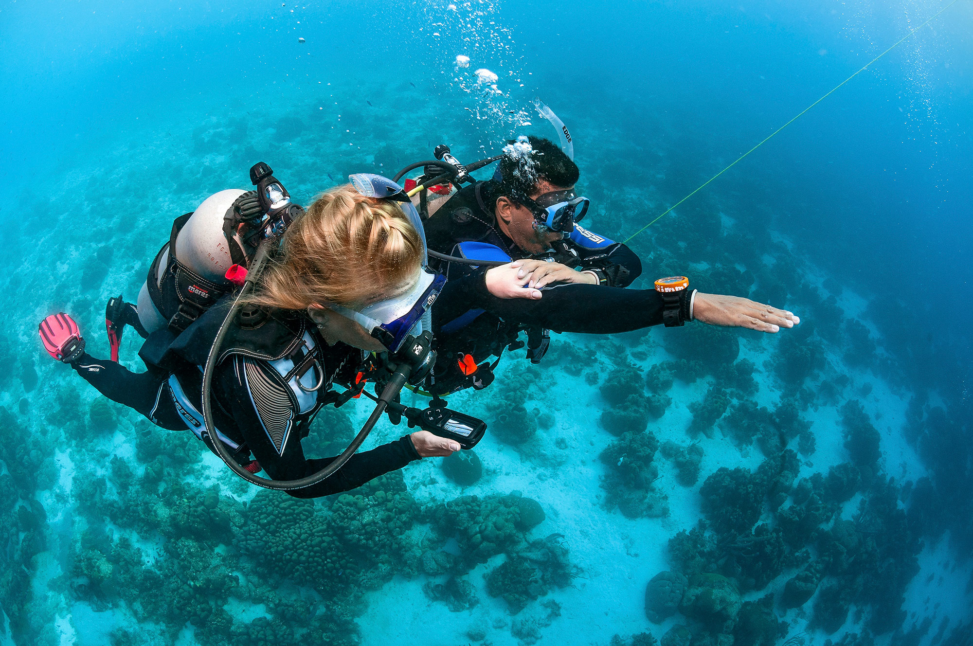Scuba Diving: A female diver checks an oxygen level - the key to underwater survival. 2000x1330 HD Background.