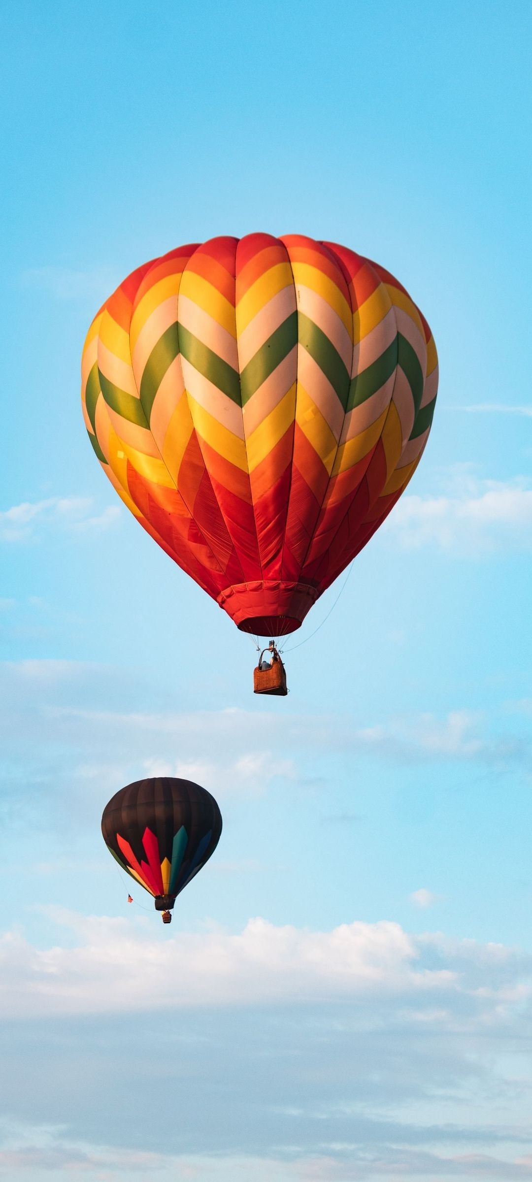 Air Sports: Two balloons move in the direction of the wind in the morning, Flying in the clouds. 1080x2400 HD Background.