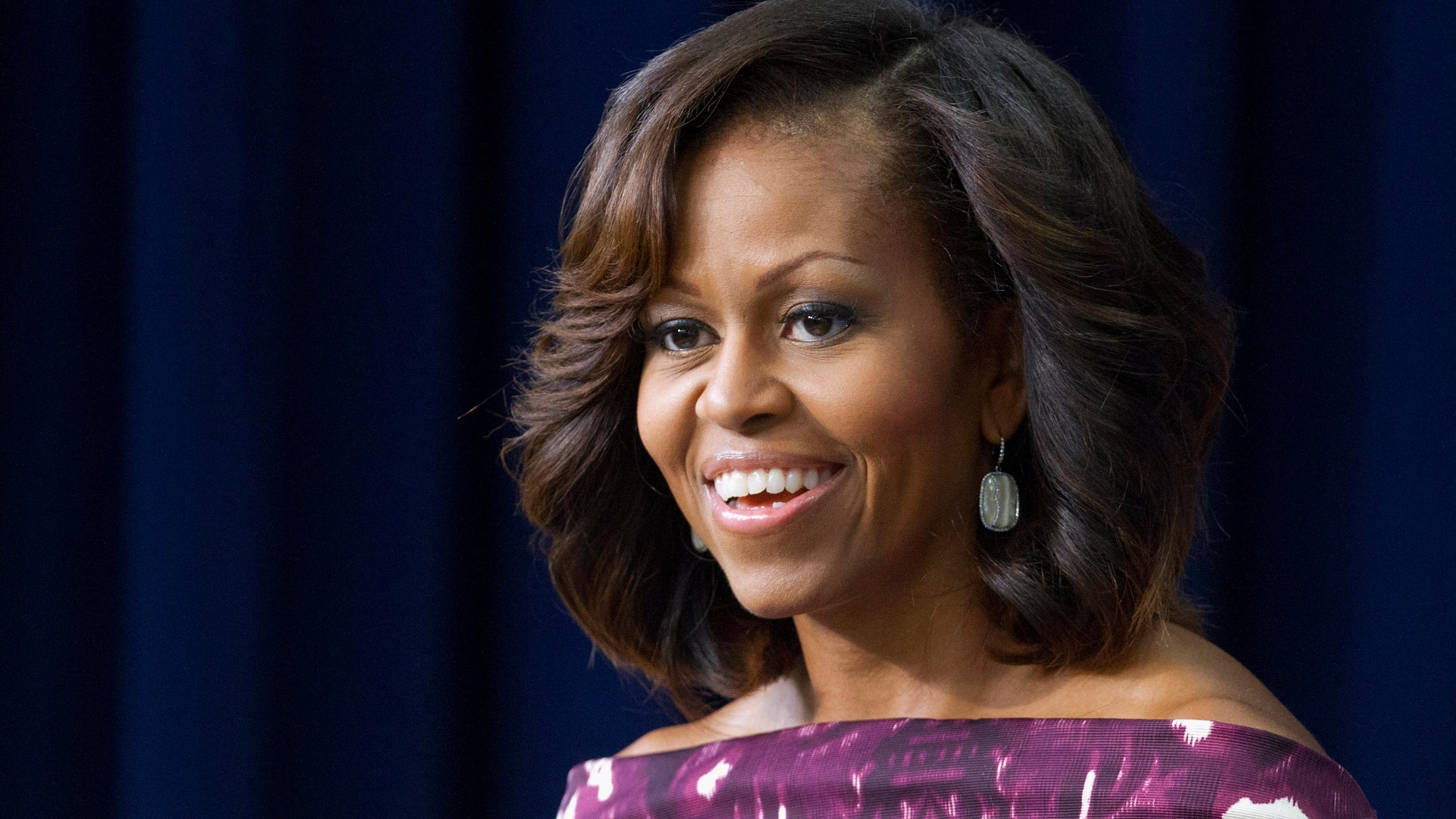 Michelle Obama: As first lady, she focused her attention on social issues such as poverty, healthy living and education. 1920x1080 Full HD Background.