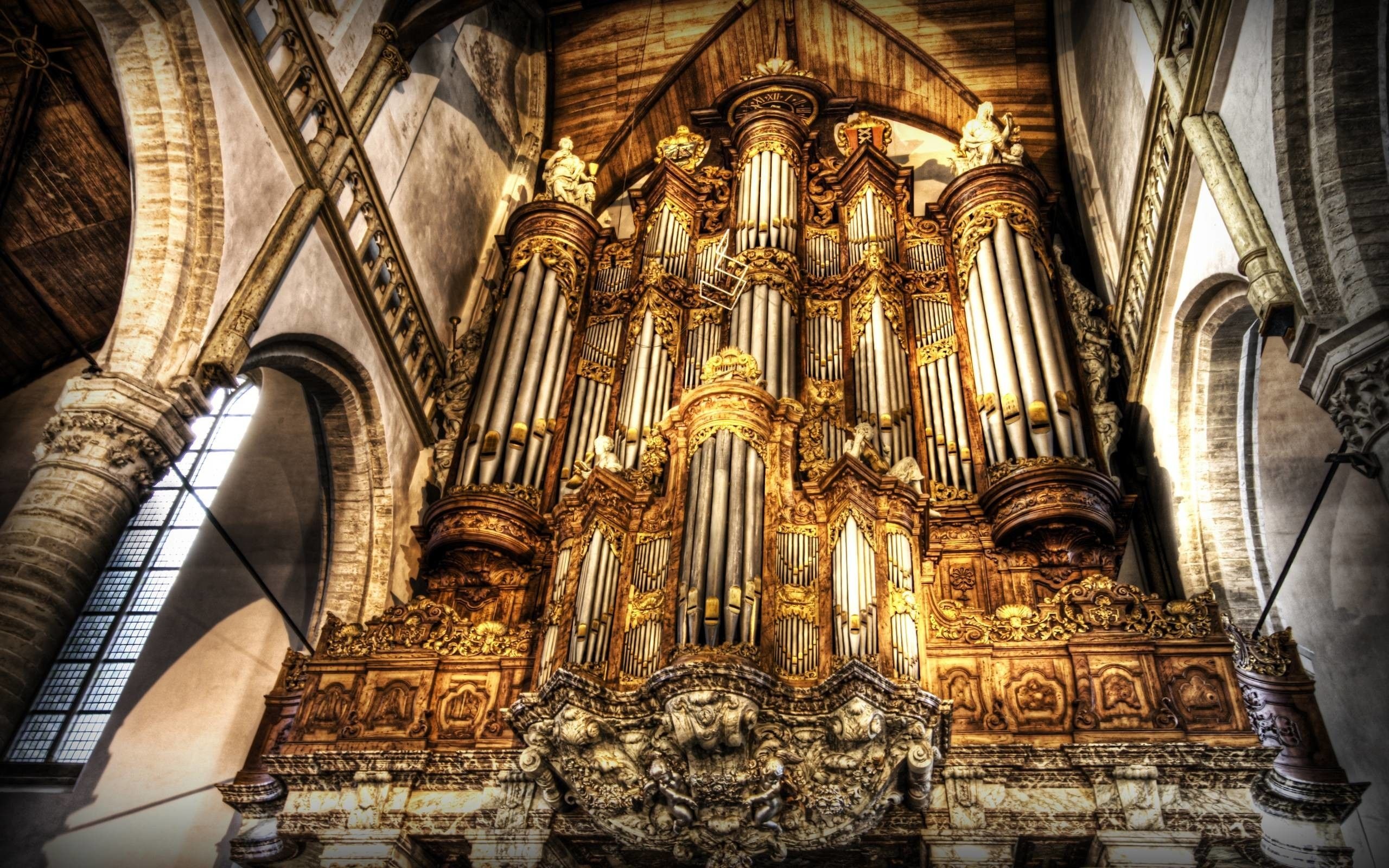 Pipe Organ: A musical instrument with a keyboard in which sound is produced by air being forced through tubes. 2560x1600 HD Background.