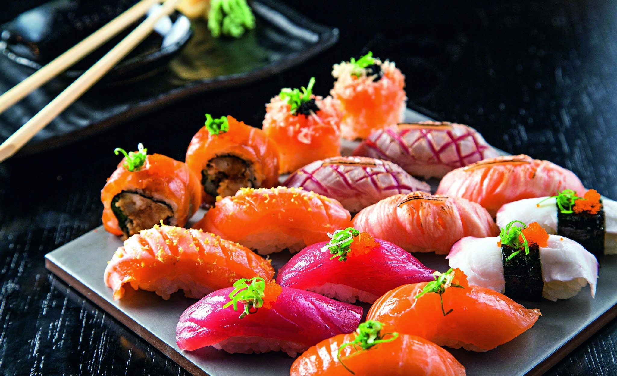 Sushi: Nigiri-zushi, a hand-formed oblong of rice, topped sliced raw seafood. 2050x1250 HD Background.