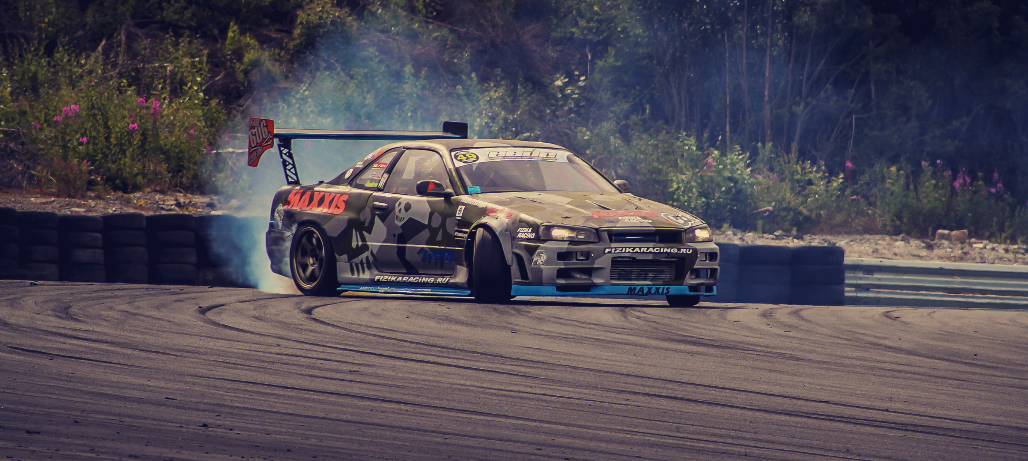 Drifting: Maxxis tires, Nissan sports car, Racing track, Competitive event. 3460x1560 Dual Screen Wallpaper.