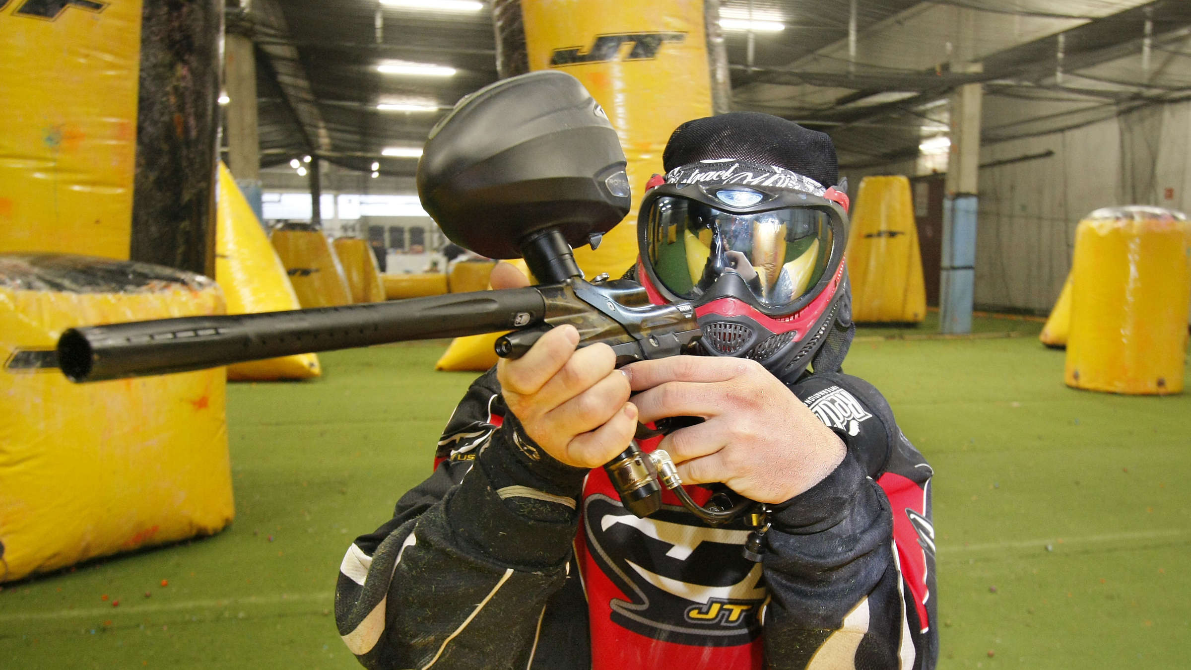 Paintball: A player during a friendly game at an indoor combat facility, Protective equipment and a marker. 2400x1350 HD Background.
