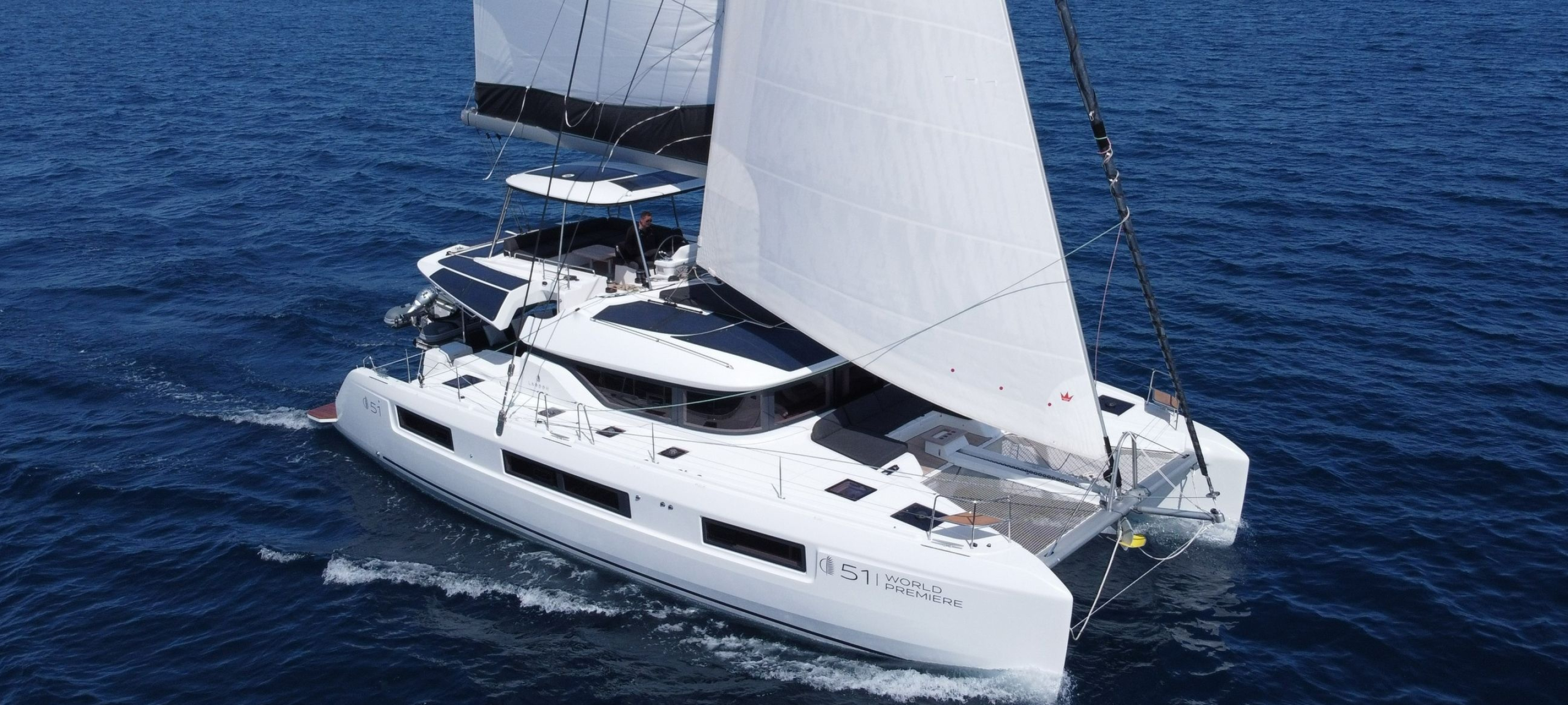Catamaran: Lagoon 51, An optimized flybridge with separate sunbathing and dining areas. 2880x1300 Dual Screen Background.