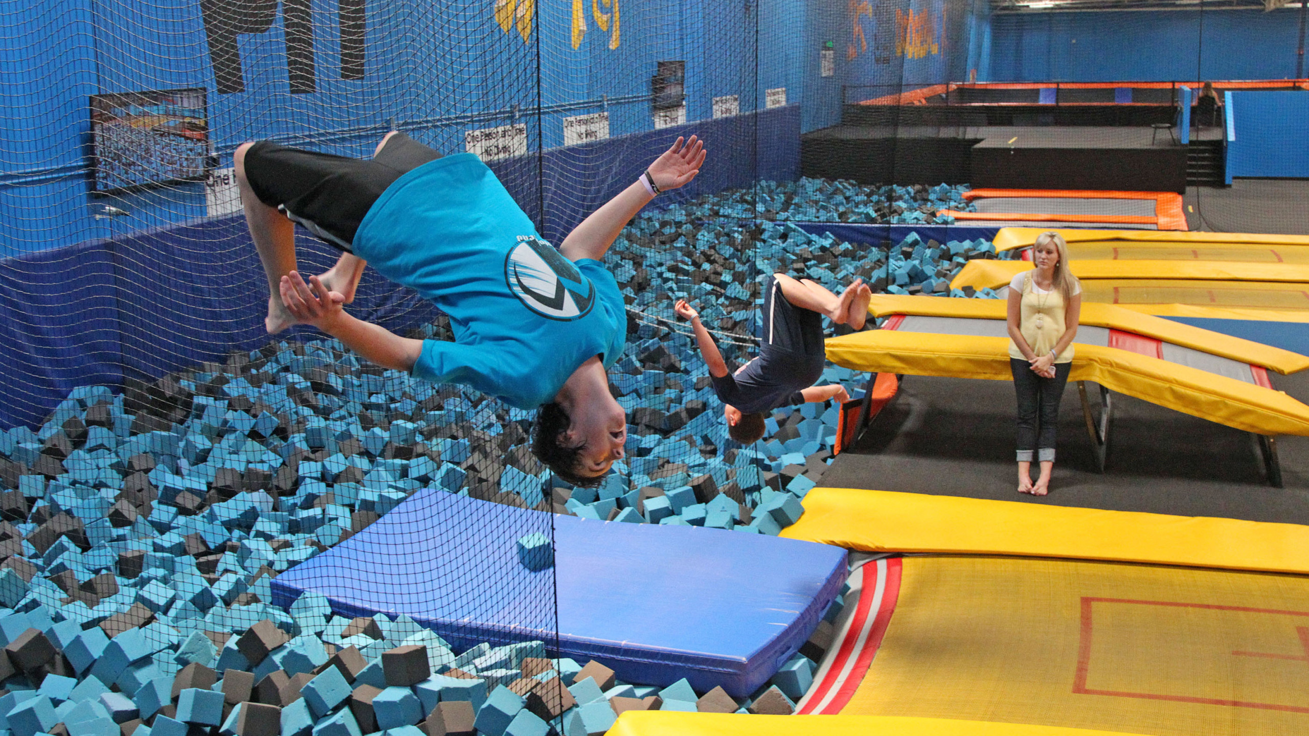 Trampolining: A trampoline park - a leisure facility with various types of jumping equipment available. 2560x1440 HD Wallpaper.