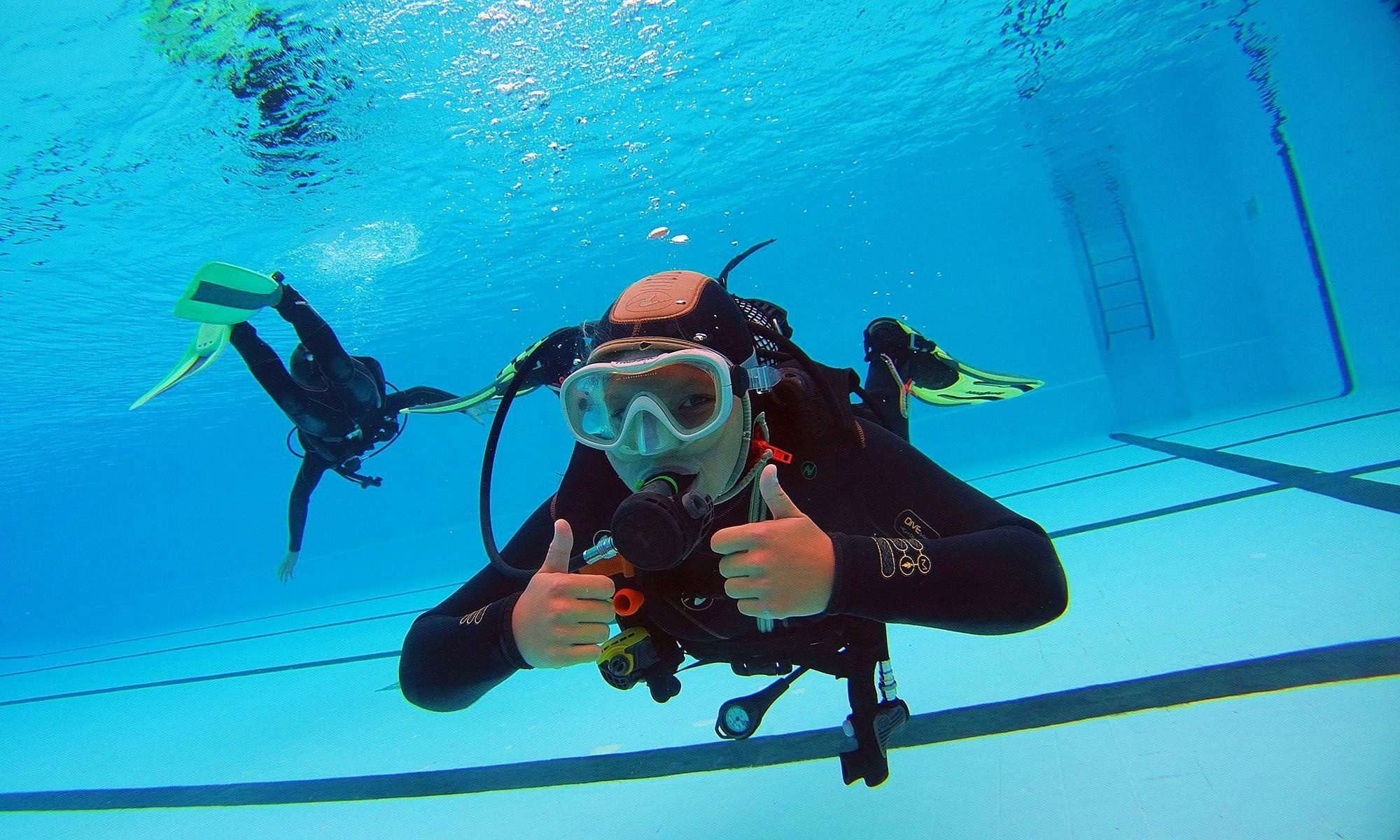 Scuba Diving: Underwater swimming training session in a pool, A trial use of an open circuit apparatus. 2000x1200 HD Background.
