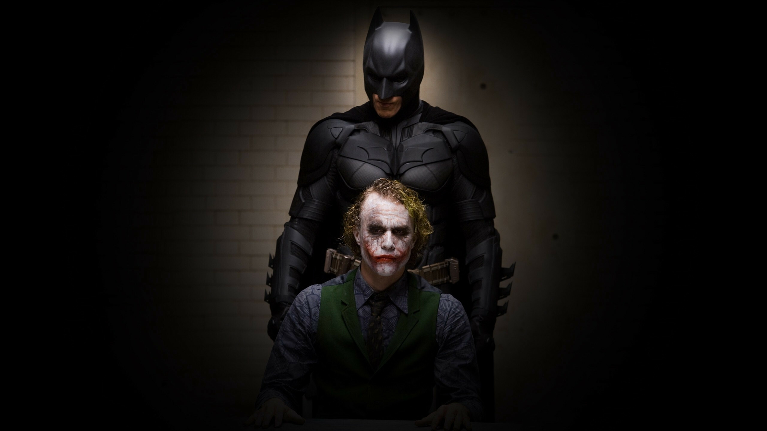 The Dark Knight: Christian Bale as Bruce Wayne / Batman, Heath Ledger as the Joker. 2560x1440 HD Wallpaper.