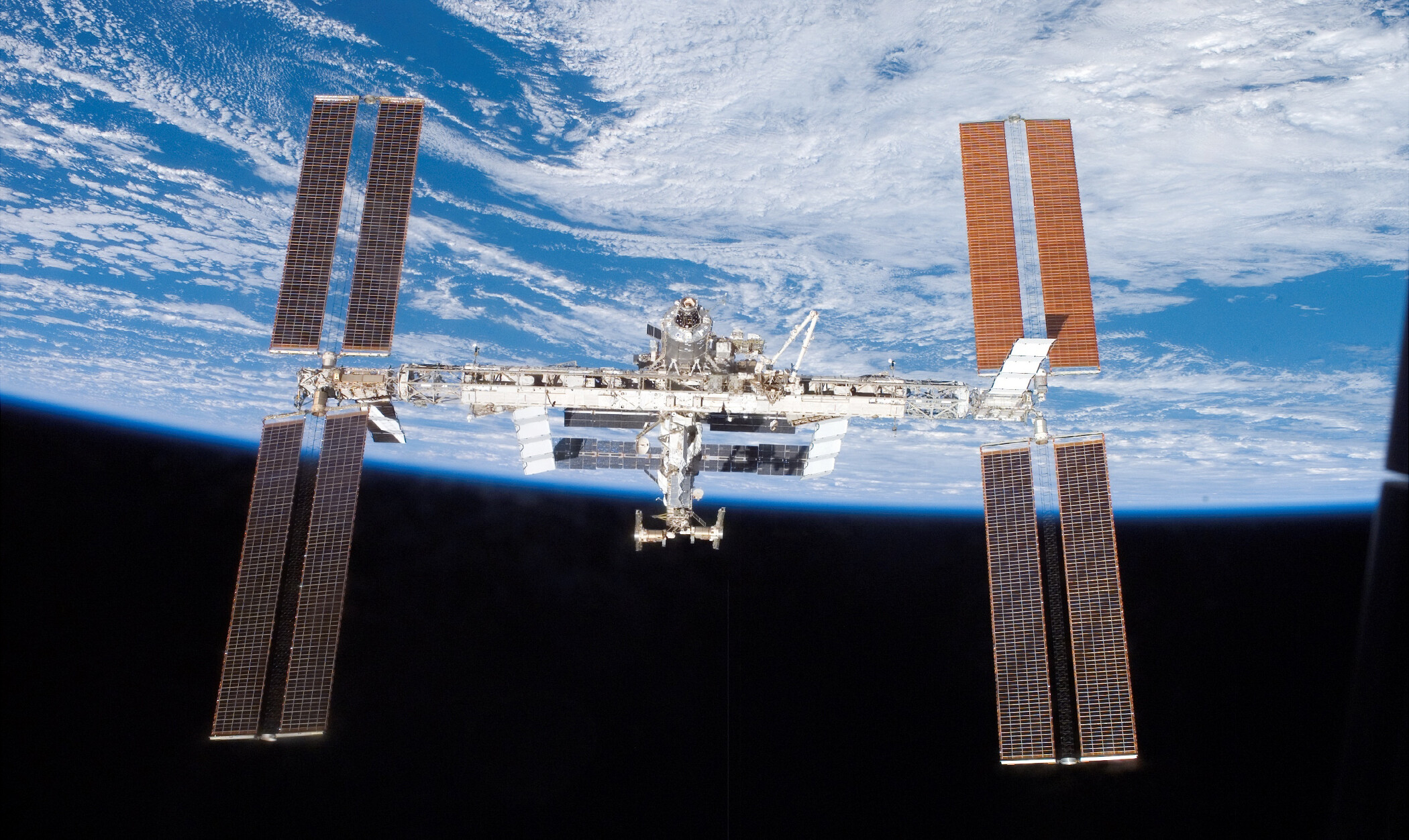 International Space Station: Scientific and engineering collaboration among five space agencies, NASA, Roscosmos, JAXA. 2100x1260 HD Background.