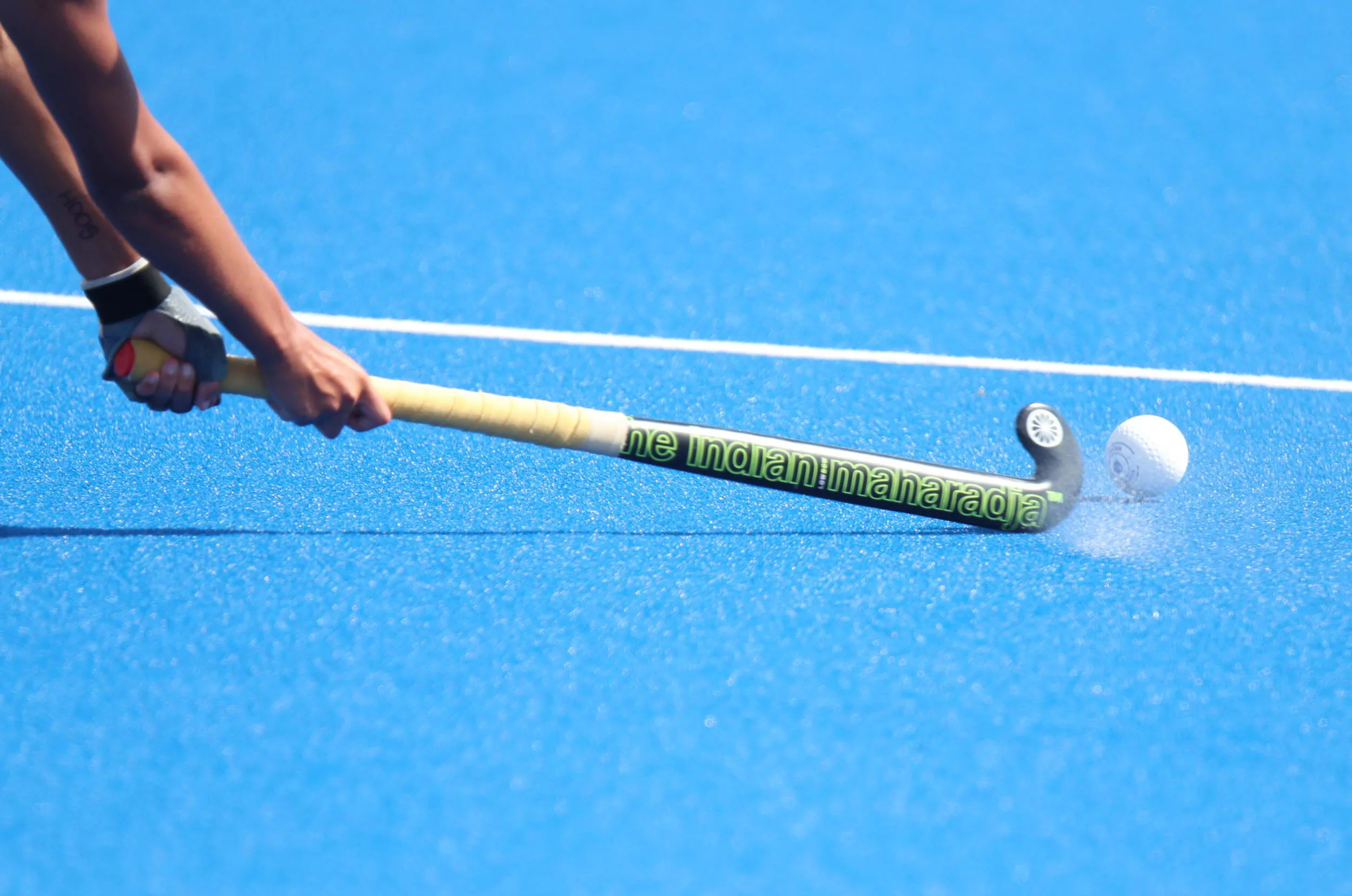 Field Hockey: A player strikes a ball with a stick at the competitive event. 2500x1660 HD Background.
