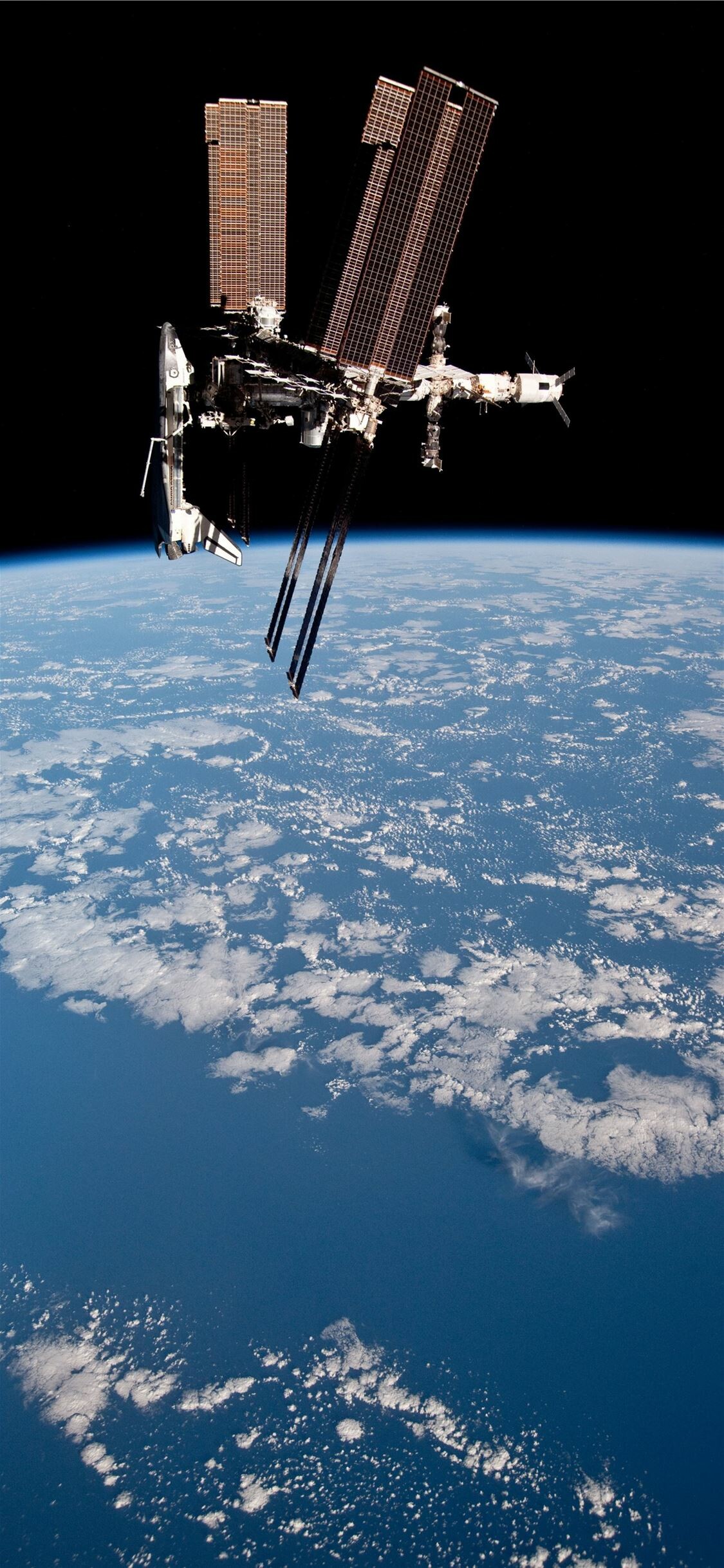 International Space Station: A habitable artificial satellite launched into low Earth orbit in 1998. 1130x2440 HD Background.