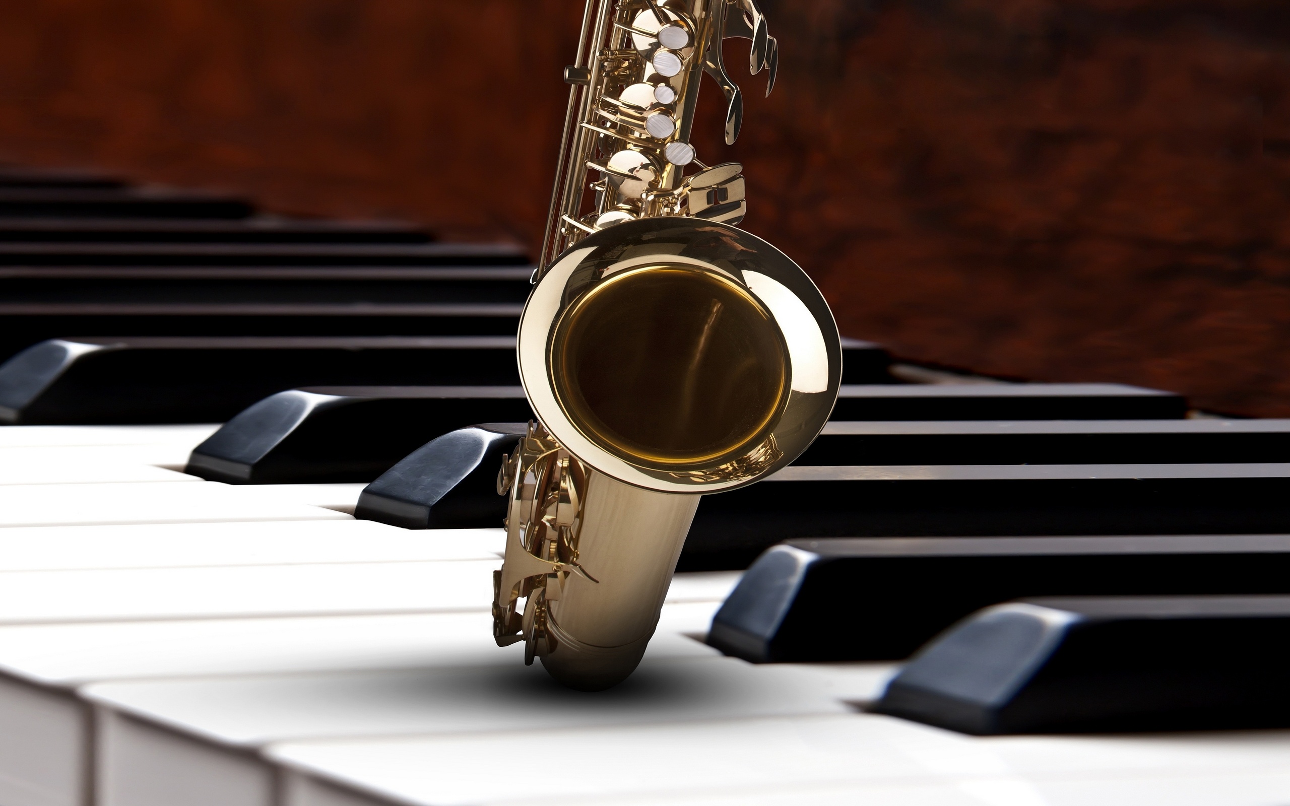 Saxophone: A metal musical instrument that belongs to the woodwind family, Piano. 2560x1600 HD Background.