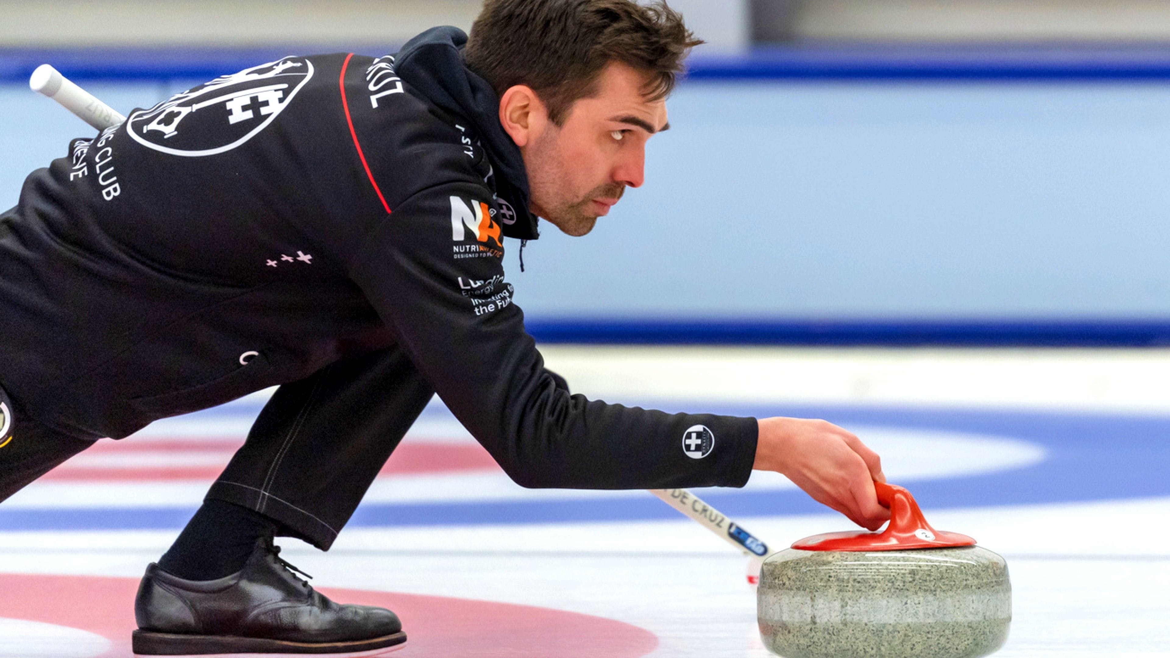 Curling: A man slides heavy, polished granite stone across the ice sheet toward the house. 3840x2160 4K Wallpaper.