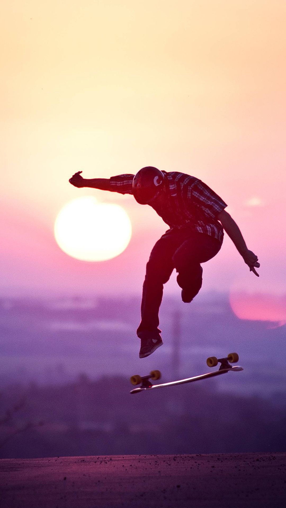 Skateboarding: Young skater doing skateboard flip trick in the sunset, Freestyle long-distance skating. 1080x1920 Full HD Background.