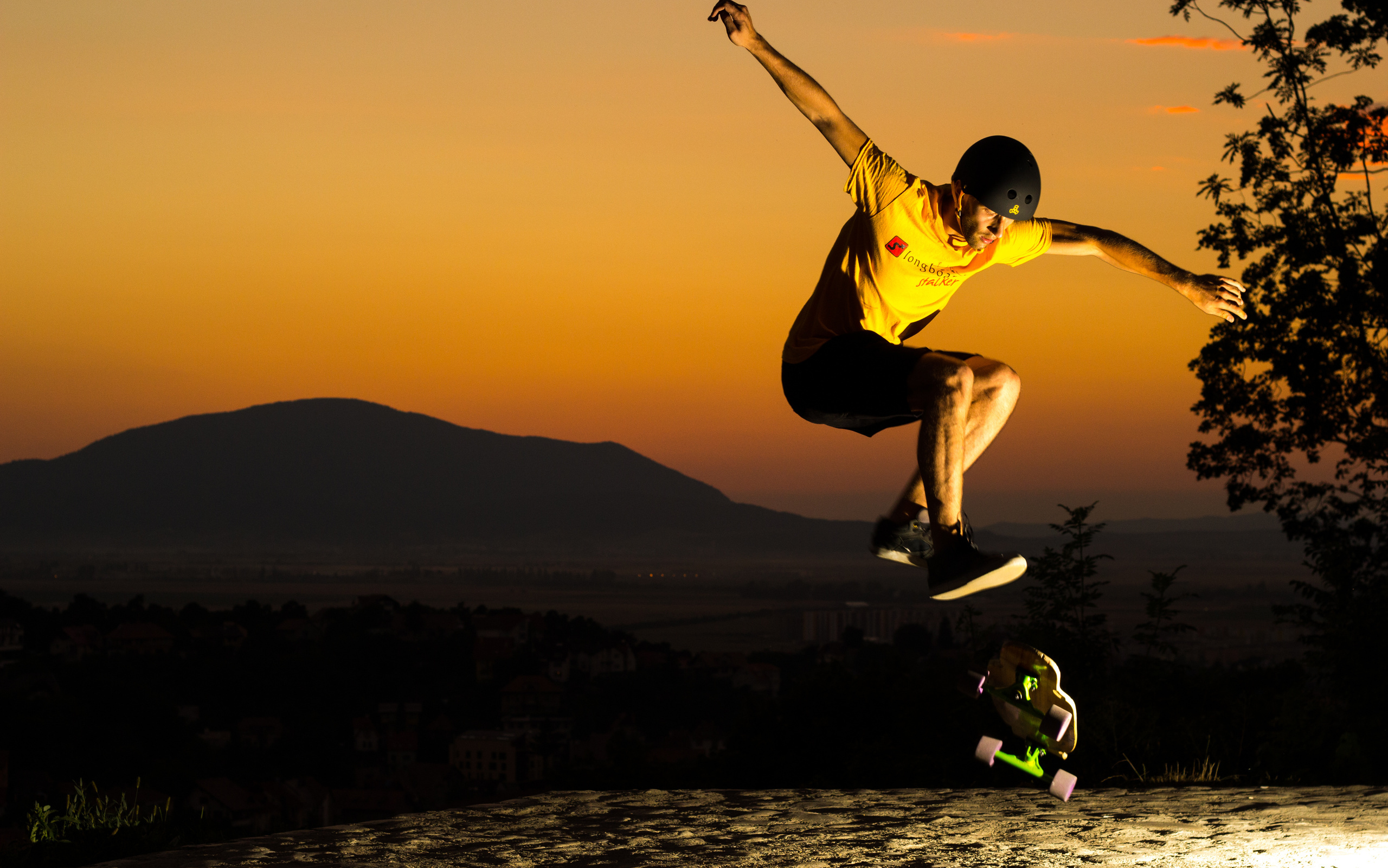 Skateboarding: Professional skater performs a trick using a modern skateboard in the sunset, Action sport. 2560x1600 HD Background.