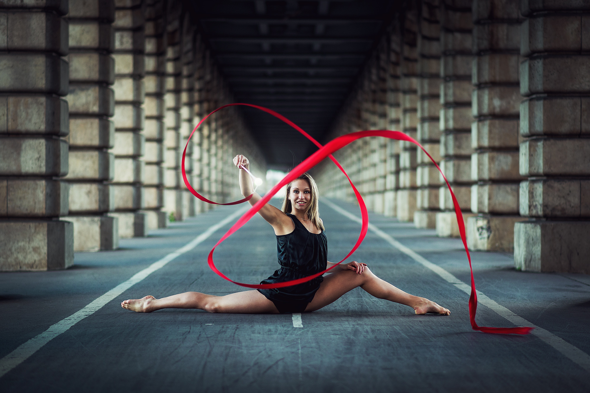Rhythmic Gymnastics: An amateur gymnast performs a leg split while drawing in the air with a ribbon, Street artistic performance. 2000x1340 HD Wallpaper.