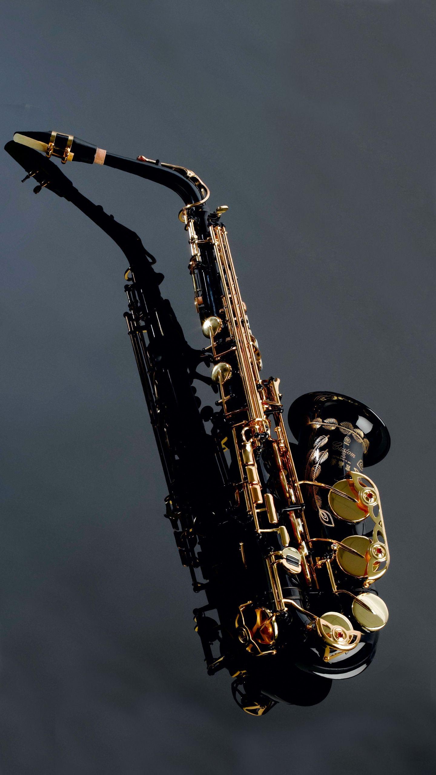 Saxophone: A musical instrument played by blowing into a mouthpiece and pressing keys with fingers. 1440x2560 HD Wallpaper.
