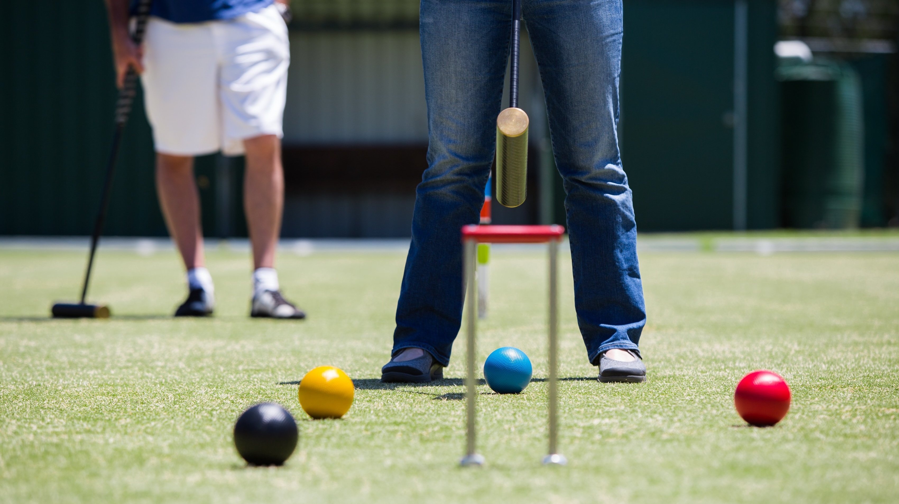 Croquet: The player picks up his own ball and puts it down next to the ball that it hit. 3410x1910 HD Background.