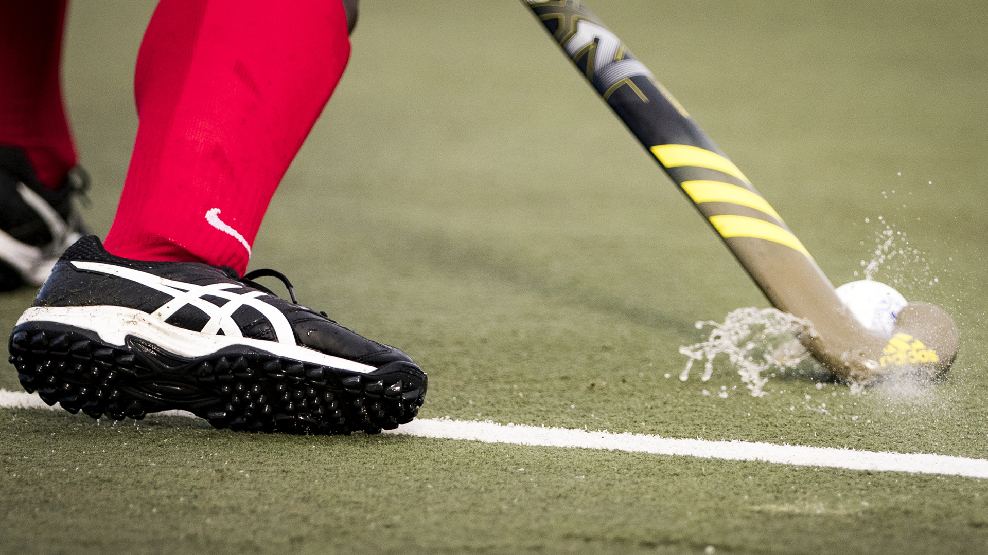 Field Hockey: A player strikes a ball with his stick, Competitive ball sport. 1920x1080 Full HD Background.