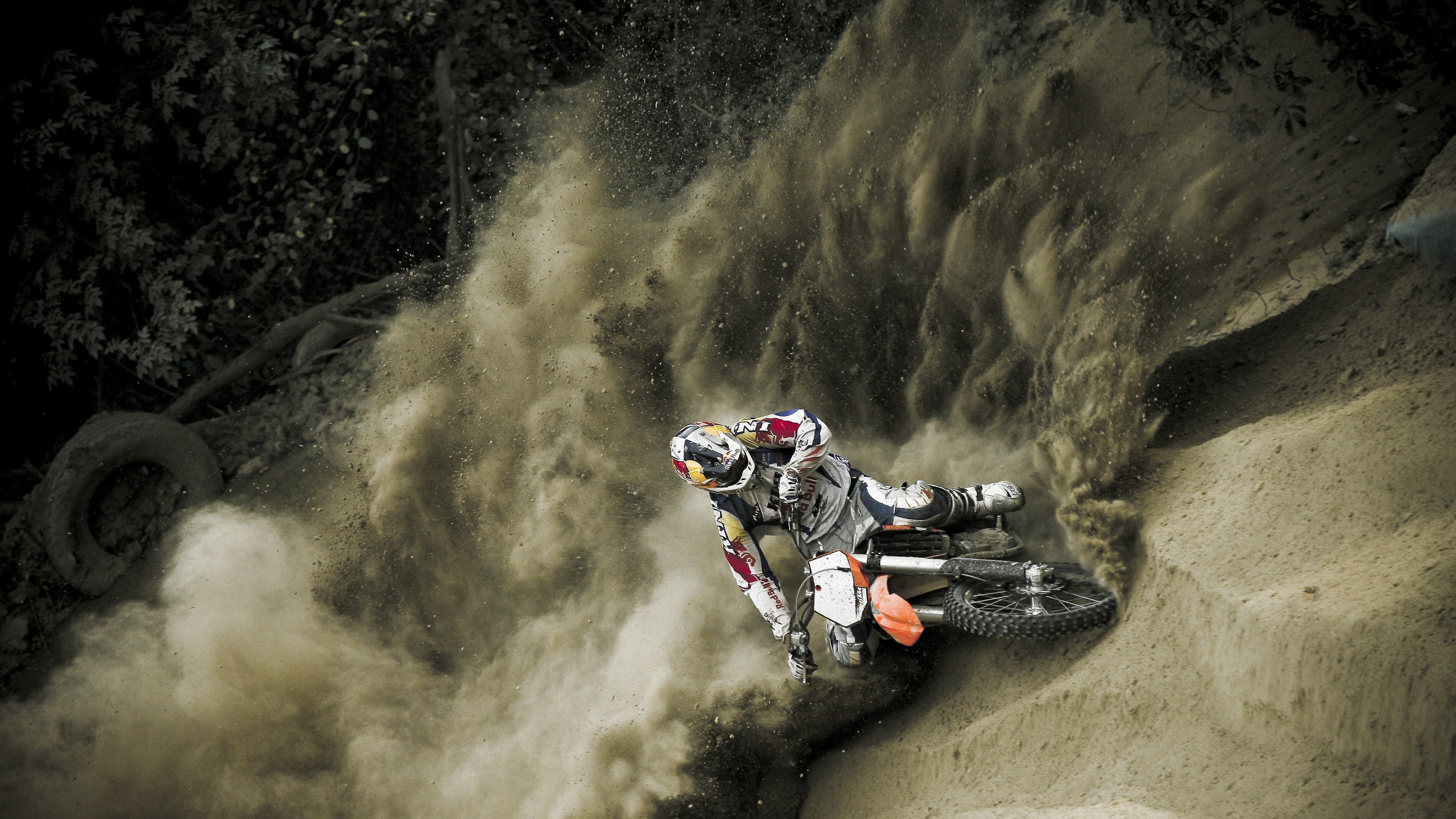 Stunt: Stuntman doing acrobatic maneuvering of the motorcycle in the sand, KTM dirt bike. 3840x2160 4K Wallpaper.