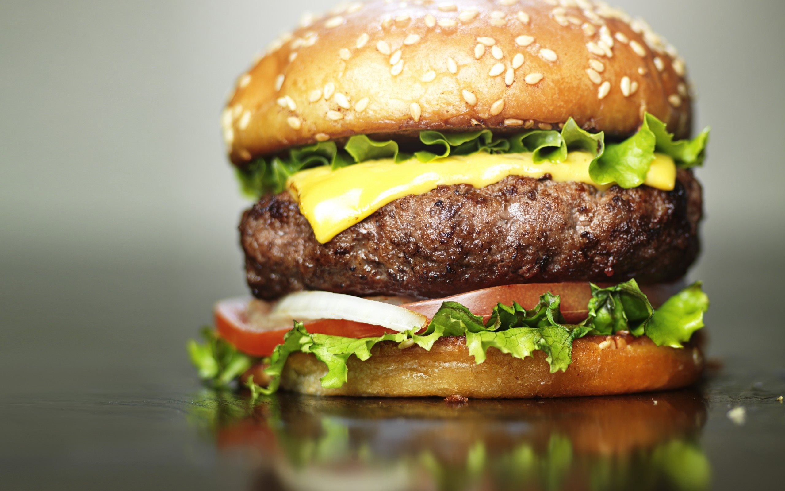 Hamburger: Seasoned with salt and pepper, Cooked on a grill, stovetop, or barbecue. 2560x1600 HD Background.