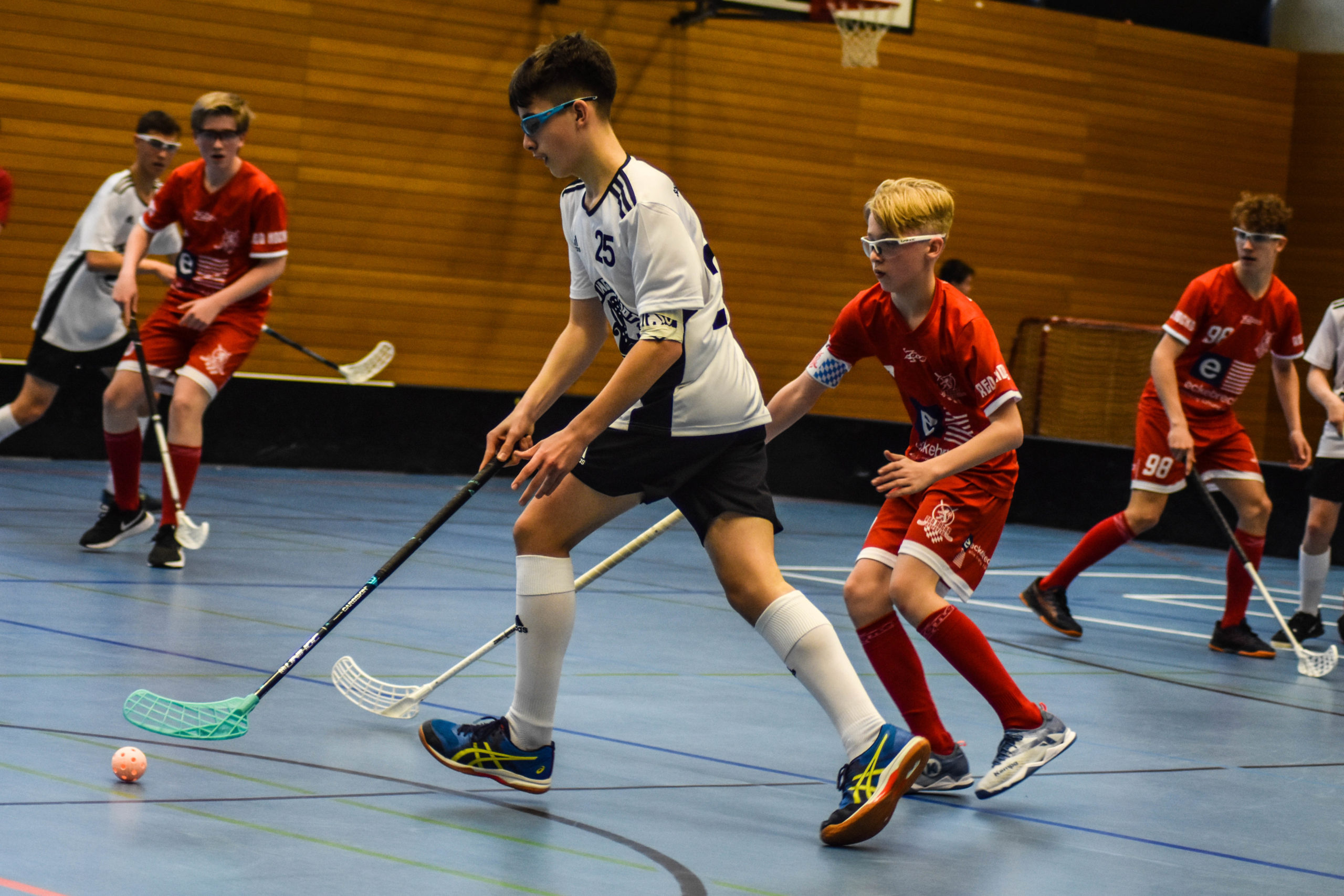 Floorball: A type of indoor floor hockey with five players and a goalkeeper on each team. 2560x1710 HD Background.