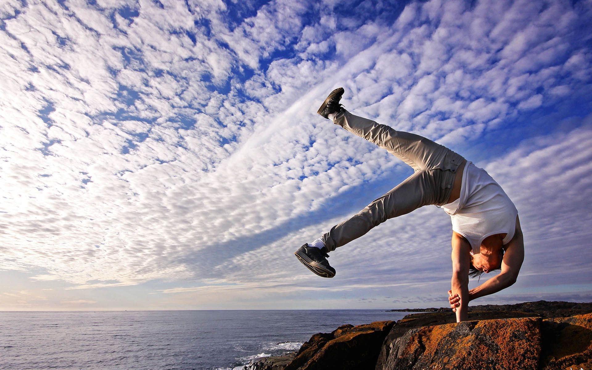 Acrobatic Gymnastics: Handstand performed by a male athlete at the top of a rock, Outdoor activity. 1920x1200 HD Background.
