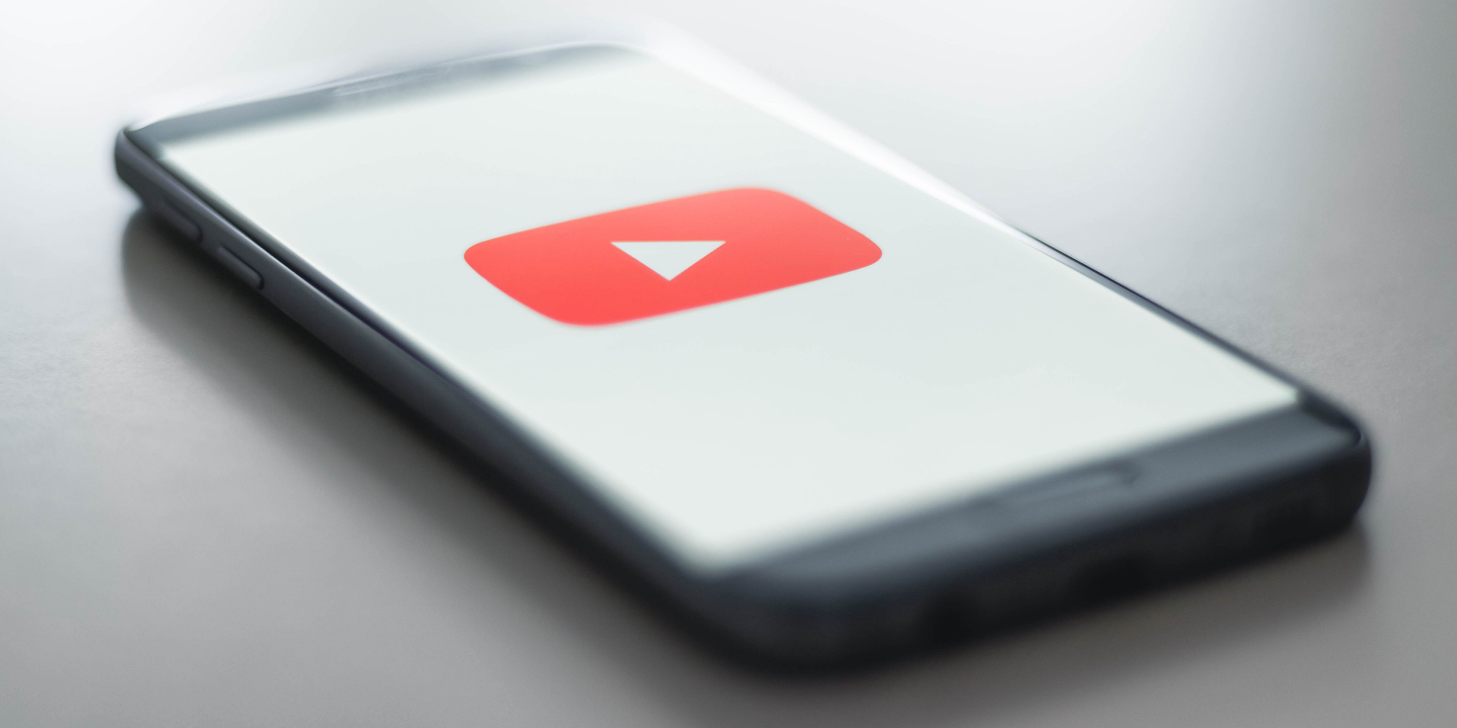 YouTube: Social media platform created in 2005, Mobile device. 3000x1500 Dual Screen Background.