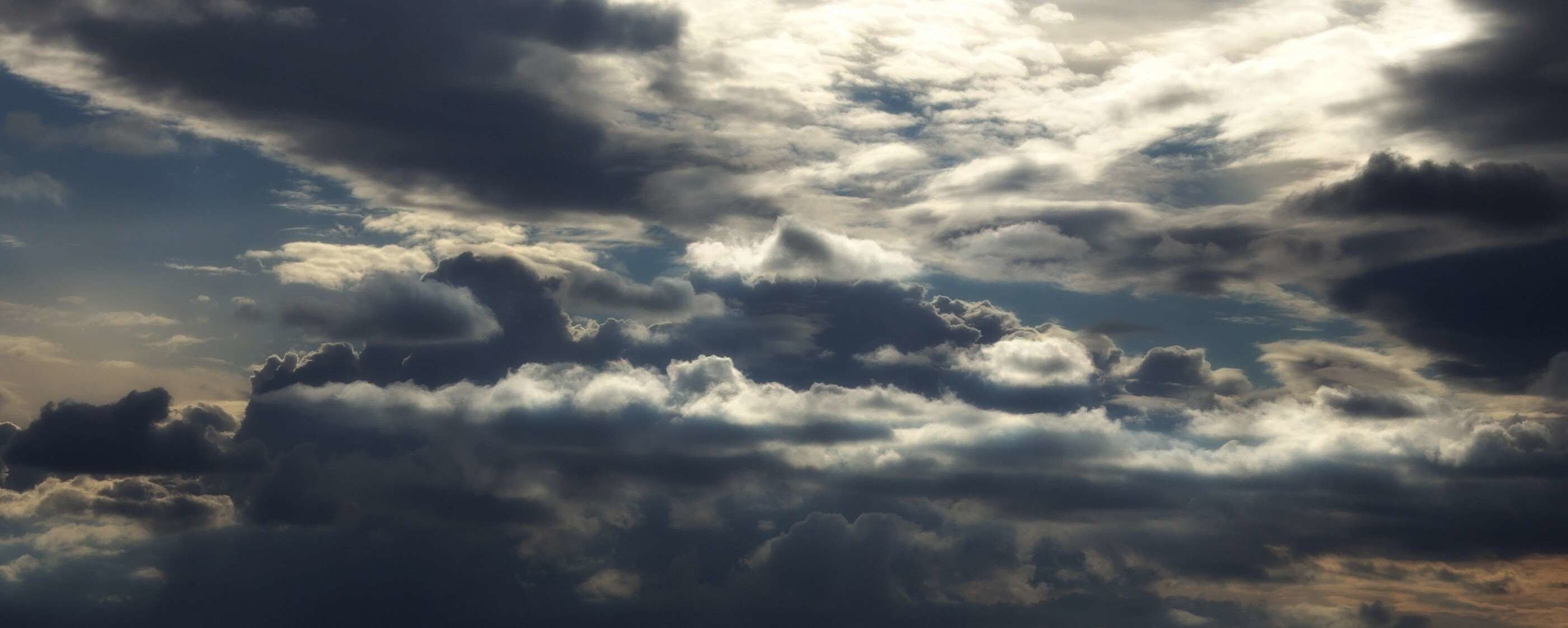 Gray Cloudy Sky: Sun illuminating the tops of clouds, Twilight, Cumulonimbus. 2810x1130 Dual Screen Wallpaper.