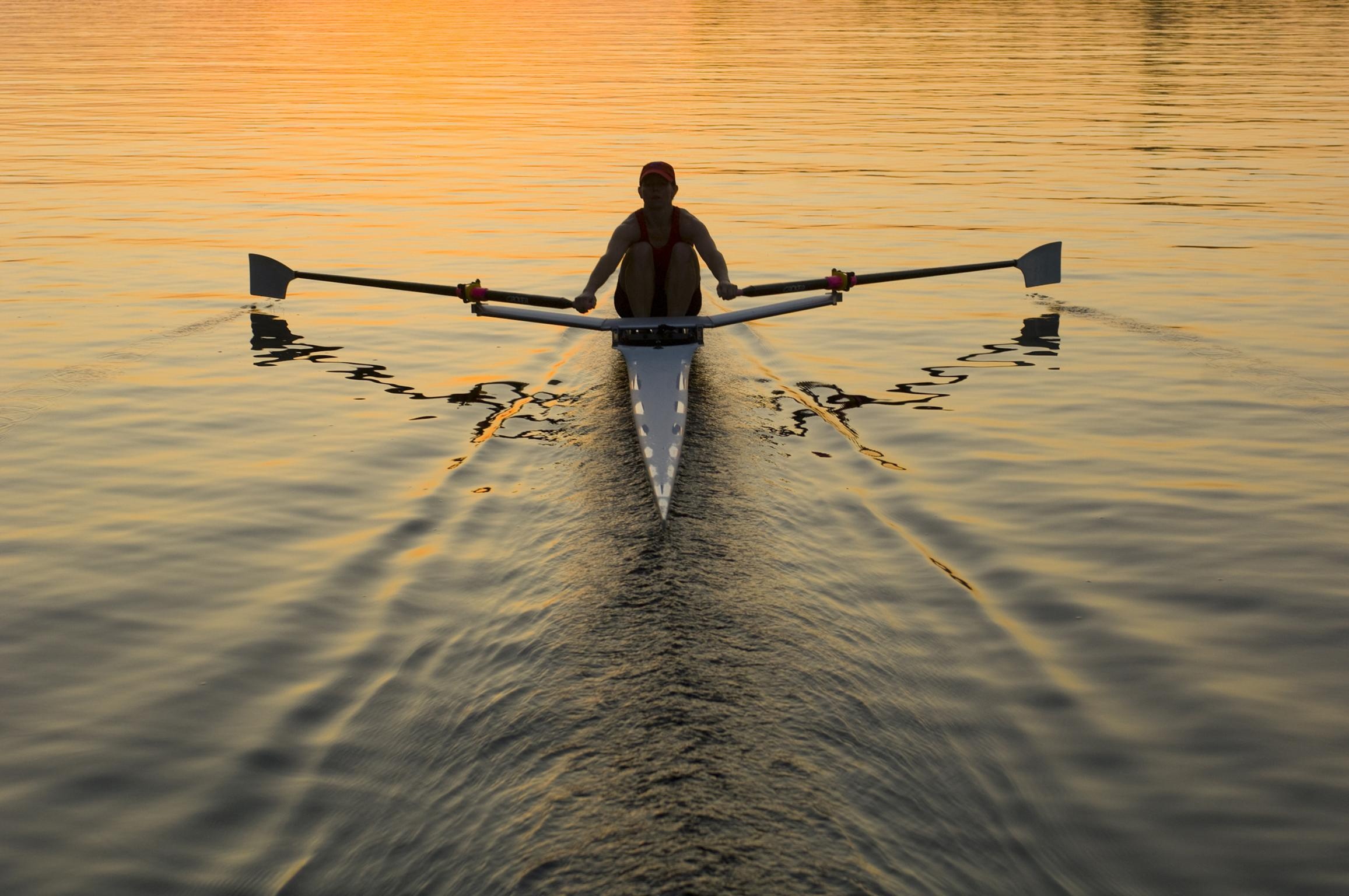 Rowing: A recreational sculling performed by a male athlete during a training session on the lake. 2320x1540 HD Background.