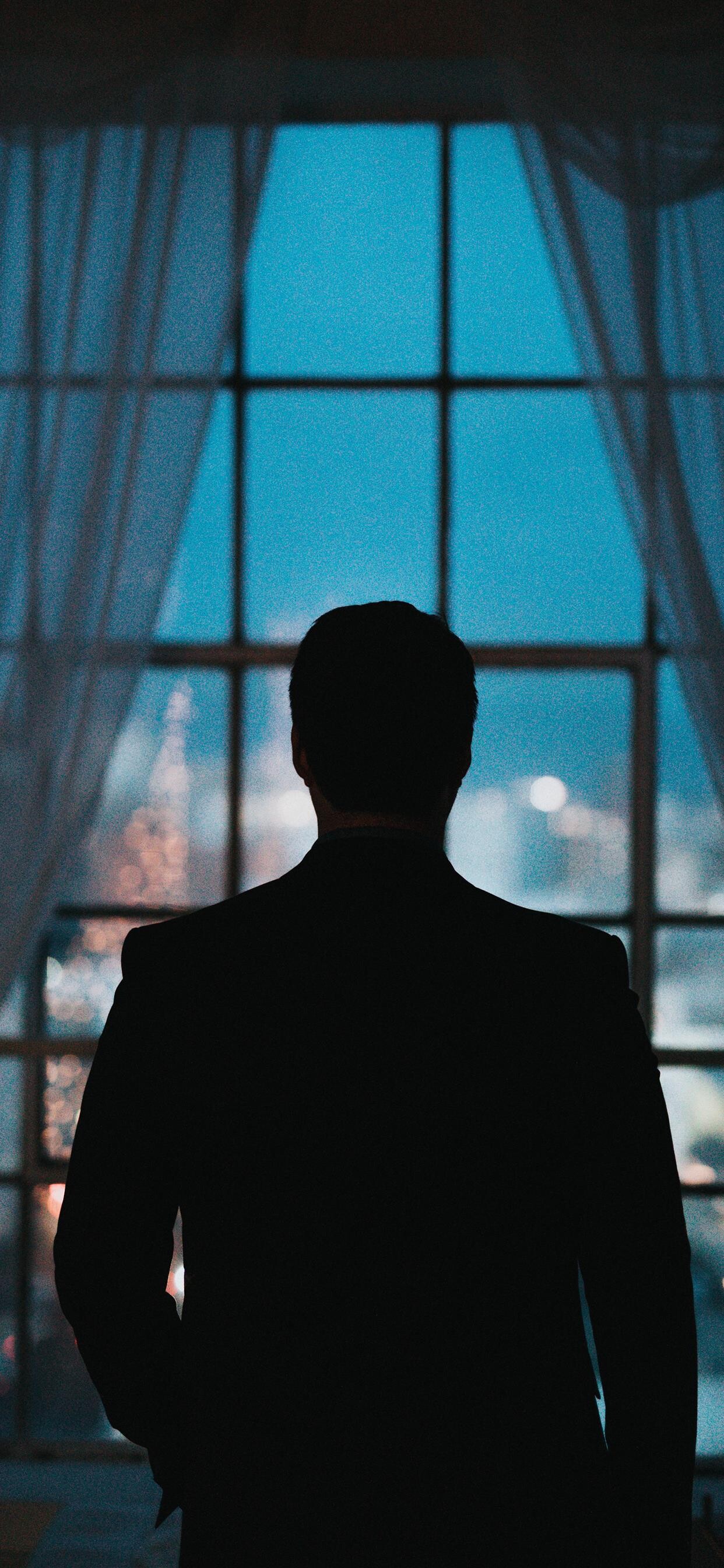 Gentleman: A person standing in front of window, Night city scenery, Silhouette. 1250x2690 HD Background.