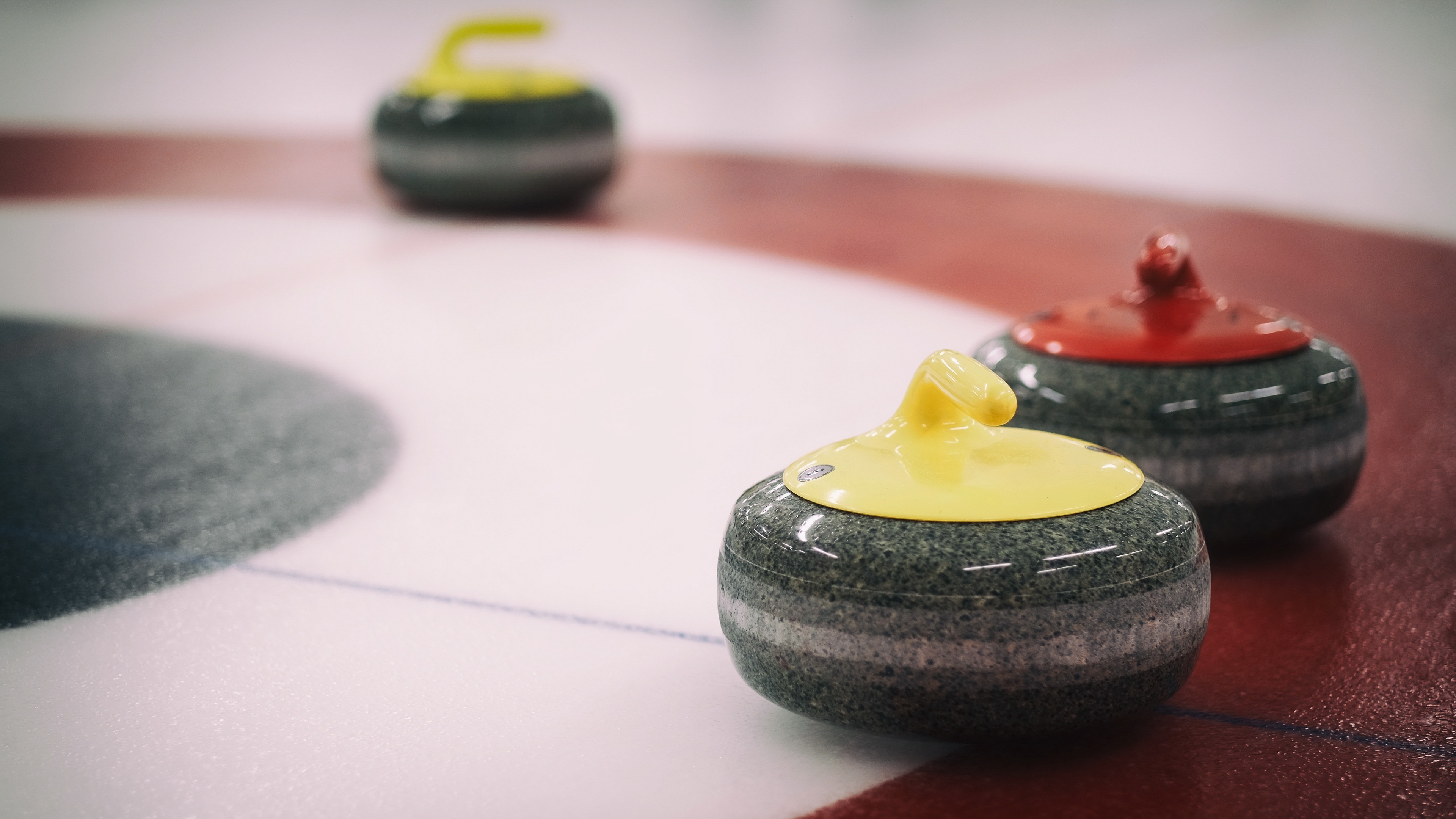 Curling: A sport in which players slide stones on a sheet of ice toward a target area. 3840x2160 4K Background.