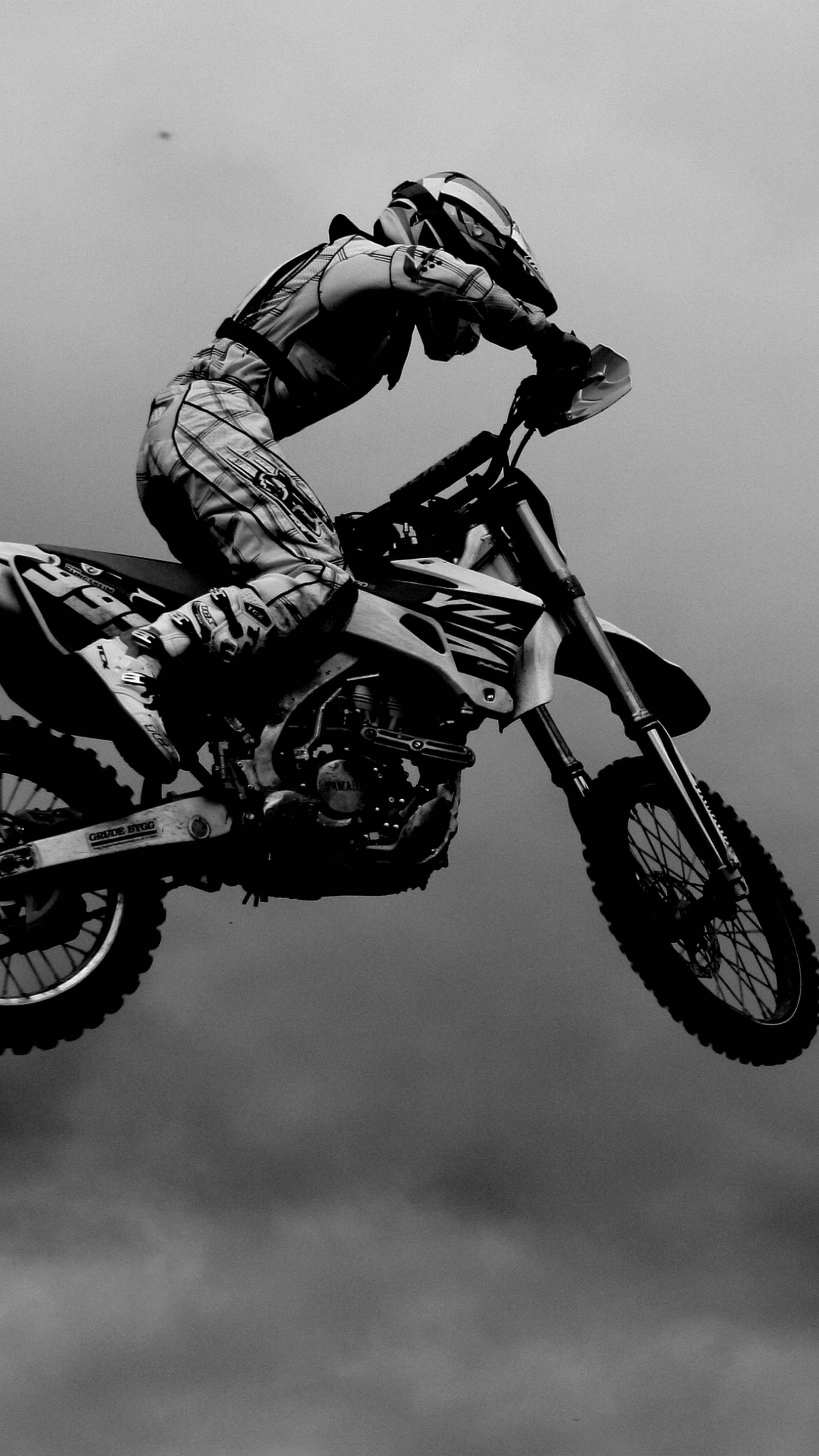 Motocross: Sportsman wears specialized protective suit and helmet, Black and white, Motorcyclist. 2160x3840 4K Background.